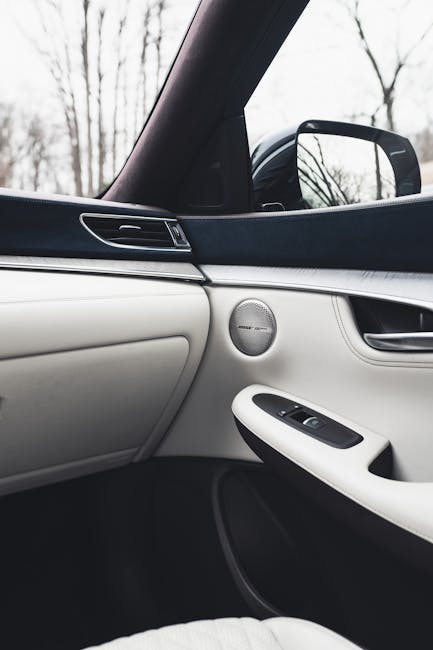 Luxurious car interior featuring white leather and sleek design with a view of the side mirror.